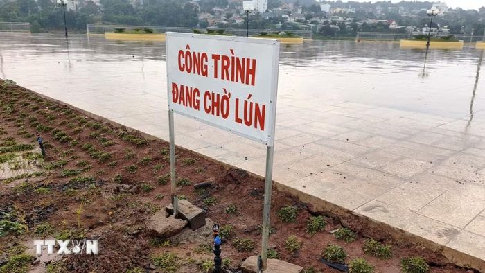 Chủ đầu tư đặt biển công trình đang chờ lún. (Ảnh: Hưng Thịnh/TTXVN)
