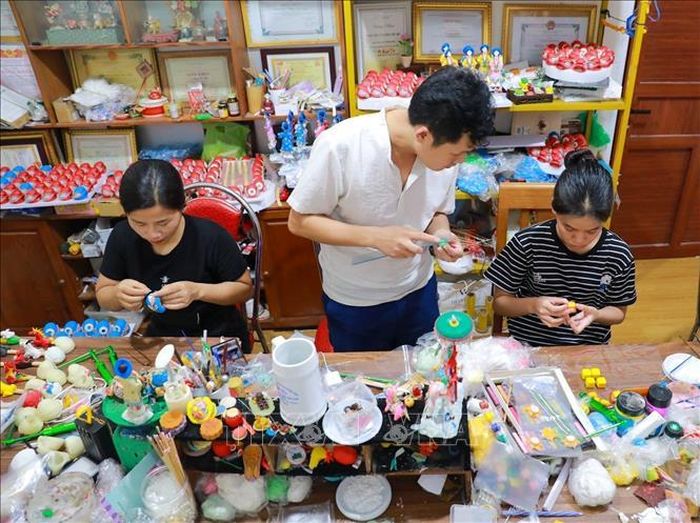 Nghệ nhân Đặng Văn Hậu tận tình chỉ dạy, hướng dẫn cho các bạn trẻ thực hiện các tác phẩm tò he.