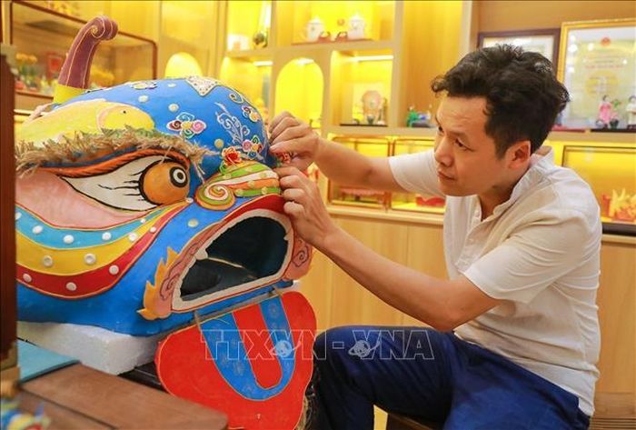 Nghệ nhân Đặng Văn Hậu thực hiện tác phẩm tò he Đầu sư tử truyền thống nặng hơn 10 kg.