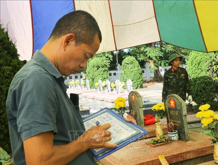Lực lượng chức năng cẩn trọng ghi chép thông tin tromg quá trình khai quật các phần mộ tại Nghĩa trang Liệt sĩ Độc Lập, xã Thanh Nưa.