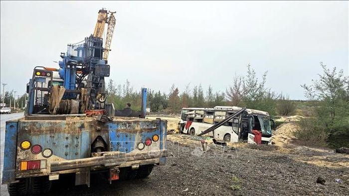 Lực lượng chức năng điều động phương tiện cứu hộ xe khách gặp tai nạn. Ảnh: TTXVN phát