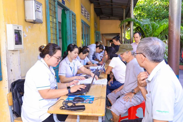 Nhân viên Bệnh viện Đa khoa Xuyên Á cập nhật thông tin vào hồ sơ sức khỏe điện tử cho người dân ngay tại điểm khám sức khỏe lưu động tại xã Củ Chi trong chương trình khám sức khỏe toàn dân.