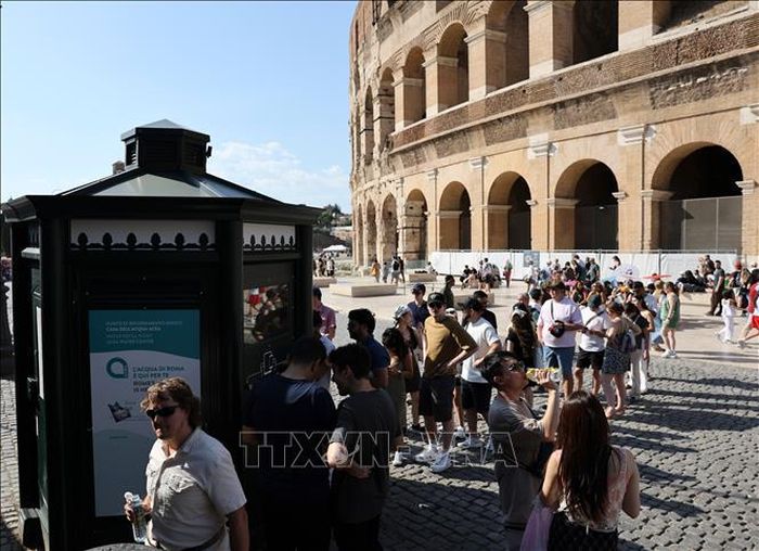 Người dân xếp hàng chờ lấy nước dưới trời nắng nóng gay gắt tại Rome, Italy. Ảnh: THX/TTXVN