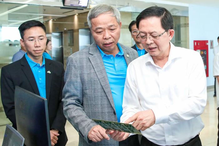 Chủ tịch CMC Nguyễn Trung Chính giới thiệu với Phó thủ tướng Hồ Quốc Dũng (phải) về các sản phẩm, giải pháp công nghệ của CMC. Ảnh: CMC.