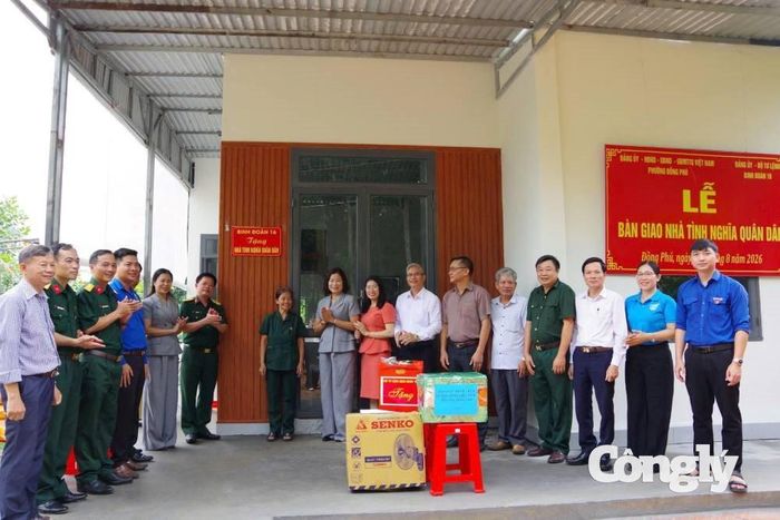 Đại diện Binh đoàn 16 và cấp ủy chính quyền địa phương chúc mừng gia đình bà Nguyễn Thị Sim bên ngôi nhà mới.