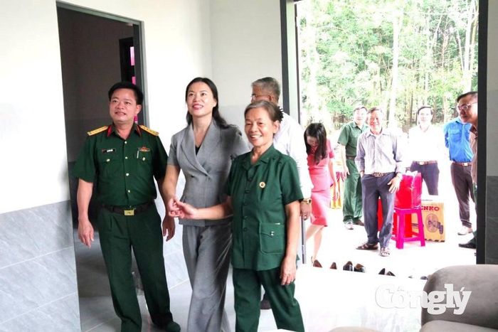 Đại diện Binh đoàn 16 và khách thăm quan nhà mới của cựu chiến binh Nguyễn Thị Sim.