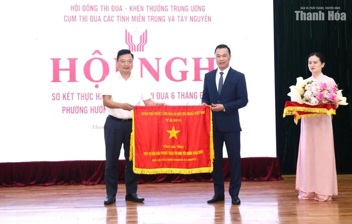 Phó Bí thư Tỉnh ủy, Chủ tịch UBND tỉnh Thanh Hóa Tô Anh Dũng trao Cờ thi đua của Chính phủ cho tỉnh Hà Tĩnh.