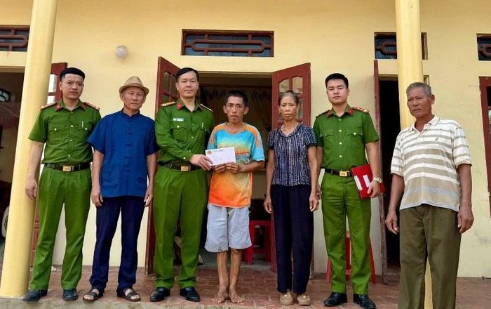 Đại úy Hoàng Văn Trang cùng cán bộ Công an xã Hồ Vương trao quà cho gia đình anh Mai Văn Ánh ở thôn Đông Sơn, xã Hồ Vương.