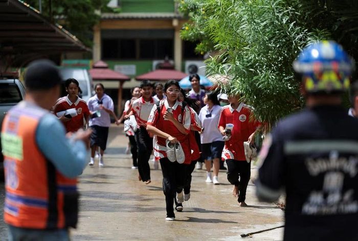 Nhiều học sinh hoảng loạn chạy khỏi khuôn viên trường, trong khi nhân viên nhà trường hỗ trợ sơ tán các em đến nơi an toàn. Ảnh: Reuters.