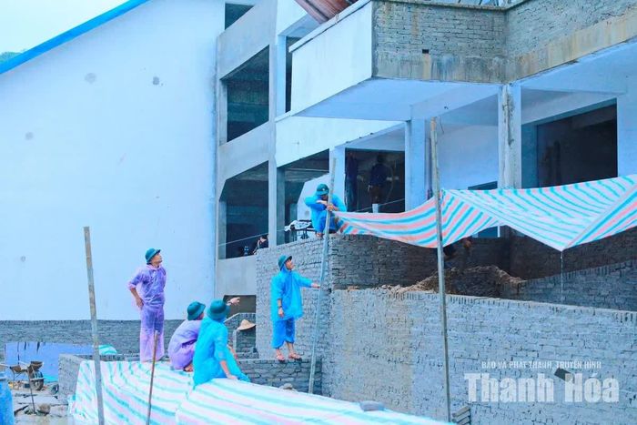 Những ngày qua trên địa bàn xã Bát Mọt thường xuyên có mưa nên công nhân phải căng bạt để thi công.