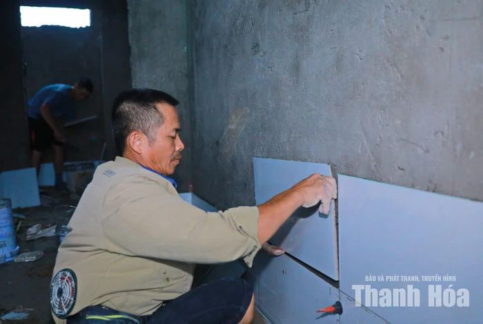 Thực hiện ốp gạch tường nhà vệ sinh dãy phòng học.