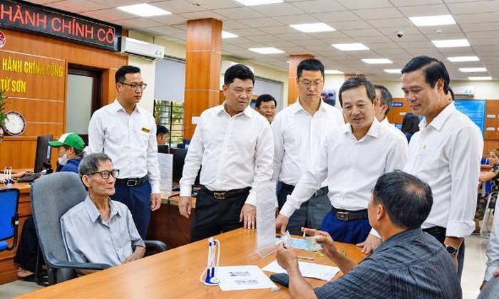  Đồng chí Nguyễn Hồng Thái cùng các đồng chí lãnh đạo tỉnh trò chuyện với người dân đến giải quyết thủ tục hành chính tại Trung tâm Phục vụ hành chính công phường Từ Sơn. 