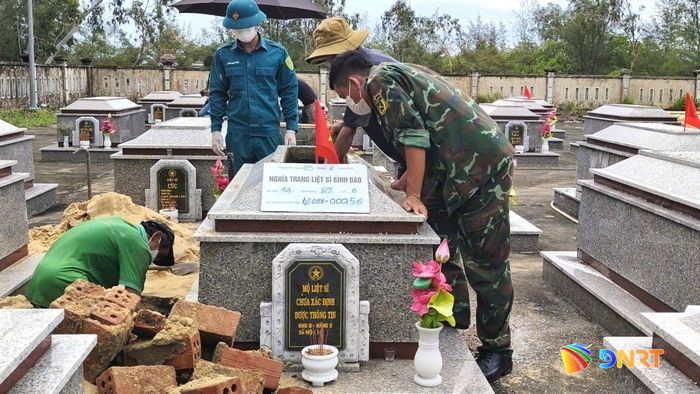 Lấy mẫu sinh phẩm hài cốt liệt sĩ chưa xác định thông tin tại Nghĩa trang liệt sĩ Bình Đào (xã Thăng An). Ảnh: HỒNG NĂM