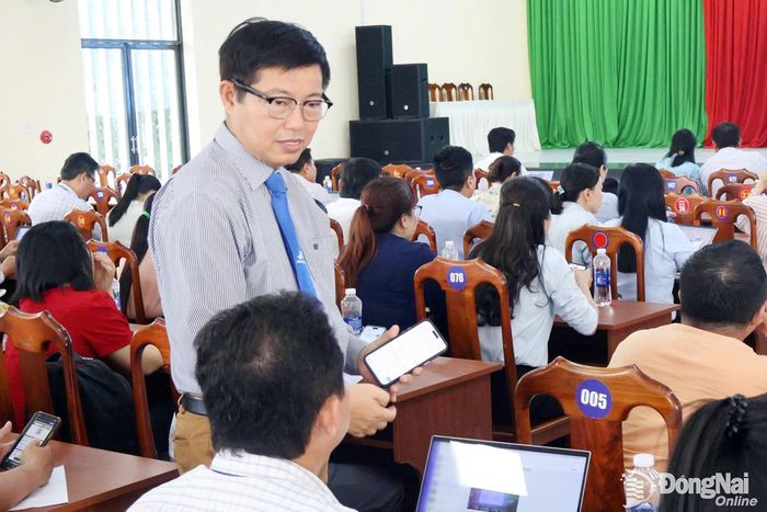 Đại diện Trường đại học Lạc Hồng hướng dẫn công chức, viên chức xã Đại Phước sử dụng phần mềm trợ lý ảo “AI công sở”. Ảnh: C.T.V