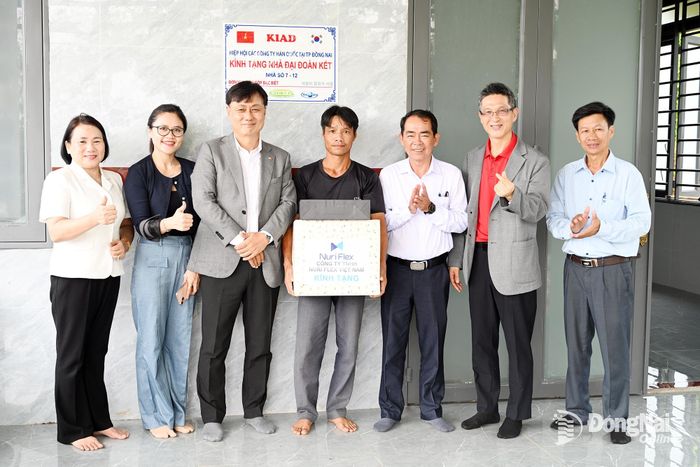 Đại diện Hiệp hội các doanh nghiệp Hàn Quốc tại Đồng Nai trao tặng quà cho những hộ được trao tặng nhà mới, hỗ trợ sửa chữa nhà đại đoàn kết. Ảnh: Phạm Quang