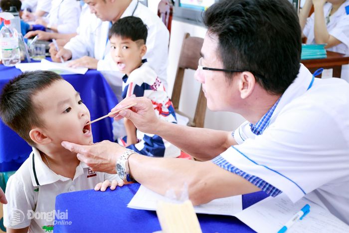 Học sinh xã Tân Tiến được bác sĩ khám sức khỏe tại chương trình. Ảnh: Bùi Dũng