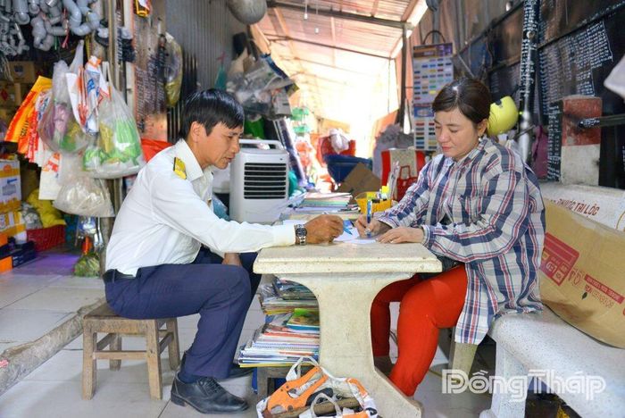 Cán bộ Thuế cơ sở 2 tỉnh Đồng Tháp trực tiếp hướng dẫn chị Dương Thị Lan Anh (xã Chợ Gạo) thực hiện ghi chép doanh thu, giúp hộ kinh doanh từng bước làm quen với phương thức quản lý mới.