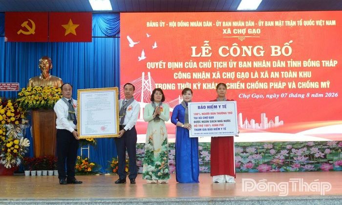 Đồng chí Phạm Thị Mai Tiên, Ủy viên Ban Thường vụ Tỉnh ủy, Chánh Văn phòng Tỉnh ủy trao Quyết định của Chủ tịch UBND tỉnh Đồng Tháp công nhận Chợ Gạo là xã An toàn khu và biểu trưng Bảo hiểm y tế toàn dân xã Chợ Gạo.