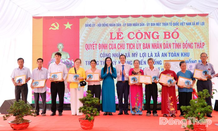 Đồng chí Nguyễn Thị Kim Tuyến và đồng chí Phạm Thanh Giang, Bí thư Đảng ủy, Chủ tịch HĐND xã trao Giấy khen và biểu trưng cho các cá nhân có thành tích tiêu biểu trong chiến đấu bảo vệ Tổ quốc giai đoạn trước năm 1975.