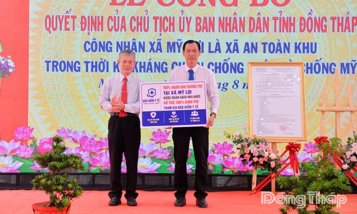 Đồng chí Đinh Văn Dũng trao biểu trưng tặng Bảo hiểm y tế cho người dân xã Mỹ Lợi.