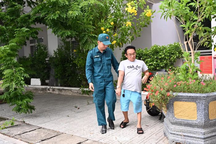 Lực lượng dân quân hỗ trợ, hướng dẫn một người khuyết tật tới khám.