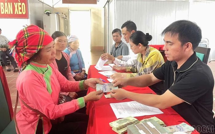 Người dân ký và nhận tiền hỗ trợ.