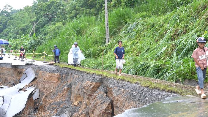 Người dân phải men theo lối tạm phía taluy dương để qua khu vực sạt lở.