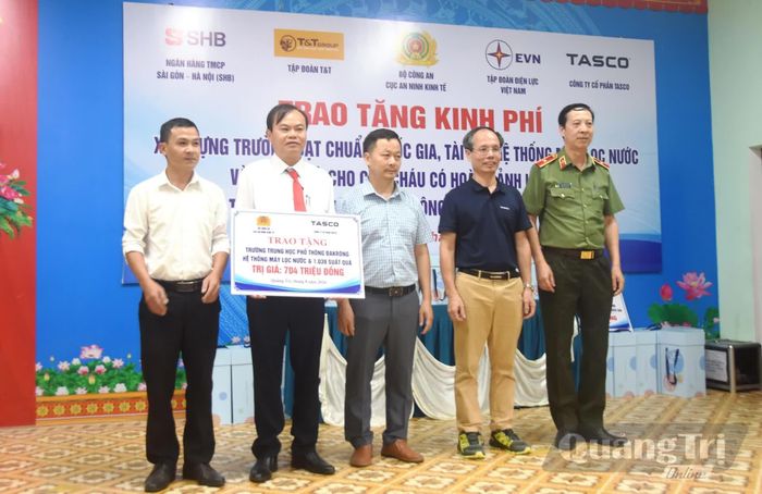 Trao biển tượng trưng hệ thống máy lọc nước và quà cho học sinh có hoàn cảnh khó khăn của nhà trường - Ảnh: Đ.V