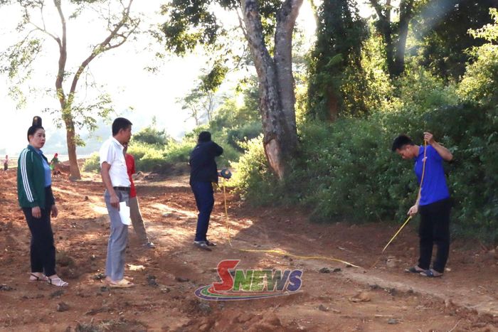 Lãnh đạo xã Phiêng Pằn phối hợp với bản Mờn đo đạc đất giải phóng mặt bằng mở rộng tuyến đường nội bản.