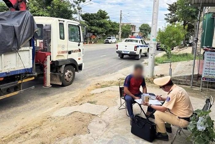 Cán bộ CSGT tỉnh Gia Lai làm việc với tài xế xe tải sử dụng thẻ nhận dạng của người khác khi điều khiển phương tiện kinh doanh vận tải hàng hóa. Ảnh: Công an cung cấp
