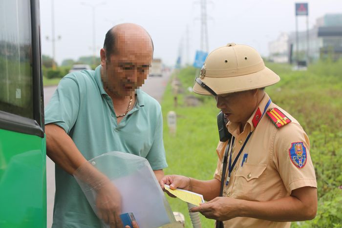 Tài xế H.N.P xuất trình giấy tờ và thẻ nhận dạng lái xe để đăng nhập thông tin theo quy định trong quá trình điều khiển xe cho lực lượng CSGT.