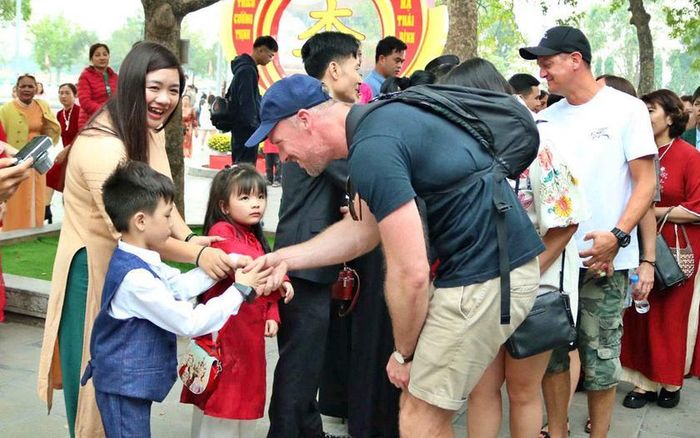 Khách du lịch quốc tế giao lưu với người dân địa phương, khi ghé thăm đền Đô (ở phường Đình Bảng, thành phố Từ Sơn, tỉnh Bắc Ninh), cách Thủ đô Hà Nội khoảng 20 km về phía Bắc. Ảnh: Báo Bắc Ninh