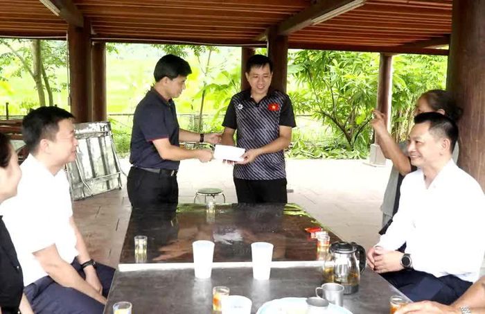 Bí thư Đảng ủy xã Hợp Thành trao quà động viên bà con thôn Tả Phời duy trì và bảo tồn Lễ "Cưn chủ" (Lên đồng) tại địa phương. Ảnh: Minh Ngọc