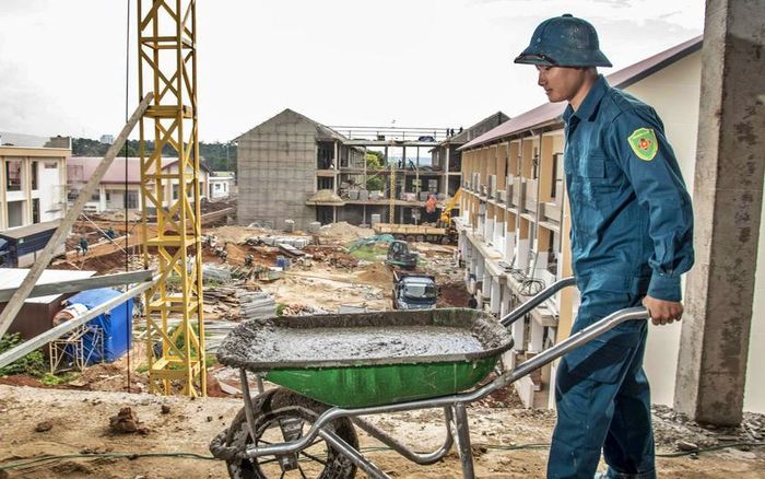 Dân quân thường trực hỗ trợ đổ bê tông trên tầng 3 khu nhà ở cho học sinh. Ảnh; Lê Văn Chương