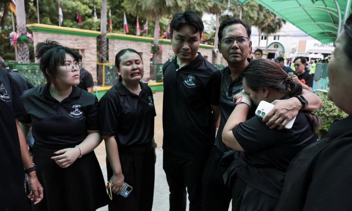 Một giáo viên bật khóc vì sốc tại hiện trường - Ảnh: Reuters