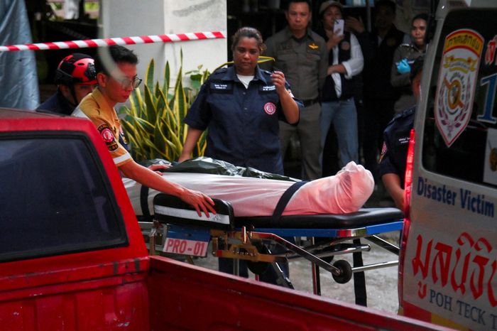 Nhân viên cứu hộ khiêng thi thể của người nhà nghi phạm. (Ảnh: Reuters)