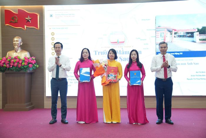 Phó Bí thư Thường trực Đảng ủy xã Thuận An Đào Xuân Trường và Chủ tịch UBND xã Nguyễn Tuấn Khanh trao quyết định đến Ban Giám hiệu Trường Mầm non Ánh Sao. Ảnh: Vân Thư