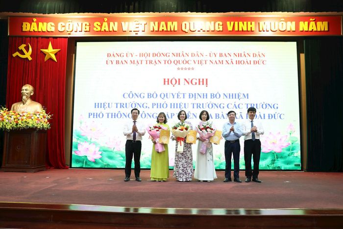 Lãnh đạo xã Hoài Đức trao quyết định và tặng hoa chúc mừng Ban giám hiệu Trường Tiểu học Lý Nam Đế. Ảnh: Hậu Lộc