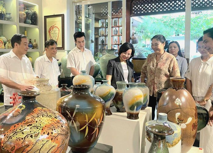 Chủ tịch Ủy ban MTTQ Việt Nam thành phố Hà Nội Bùi Huyền Mai và lãnh đạo các sở, ban, ngành thành phố thăm nơi trưng bày, giới thiệu, bán sản phẩm của HTX sản xuất kinh doanh gốm sứ Tân Thịnh (xã Bát Tràng) tháng 7-2026. Ảnh: MTTQ
