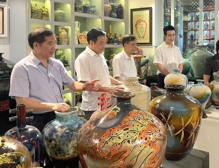 Lãnh đạo Liên minh HTX thành phố Hà Nội thăm nơi trưng bày, giới thiệu, bán sản phẩm gốm sứ ở xã Bát Tràng. Ảnh: Phương Lộc