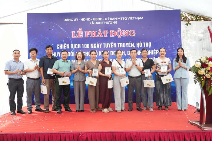 Lãnh đạo xã Đan Phượng và đại diện ngân hàng trao tài khoản cho các hộ kinh doanh. Ảnh: Nga Nguyễn