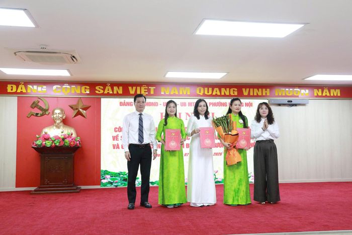 Lãnh đạo phường Dương Nội trao quyết định cho các cán bộ sau sắp xếp. Ảnh Thu Oanh