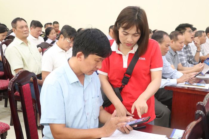 Đại diện của Viettel hướng dẫn người dân sử dụng ứng dụng Viettel Tammi. Ảnh: Thủy Linh