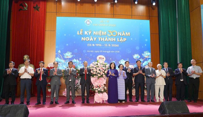 Bộ trưởng Bộ Y tế Đào Hồng Lan và các đồng chí lãnh đạo Bộ đương nhiệm, lãnh đạo Bộ qua các thời kỳ tặng hoa chúc mừng Cục Quản lý Dược. Ảnh: Trần Minh