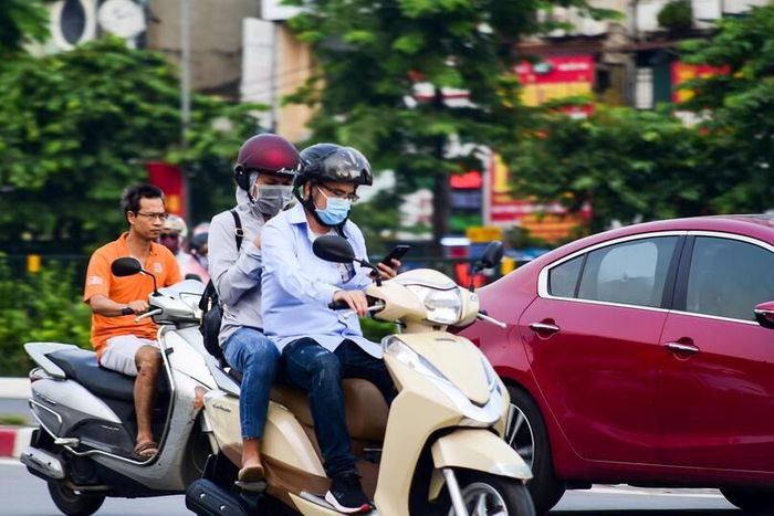Người đi xe máy vừa lái xe vừa sử dụng điện thoại. Ảnh minh hoạ