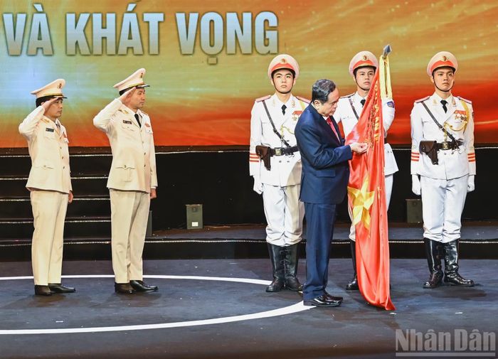 Chủ tịch Quốc hội Trần Thanh Mẫn gắn Huân chương Hồ Chí Minh lên lá cờ truyền thống của lực lượng Cảnh sát kinh tế. (Ảnh: DUY LINH)