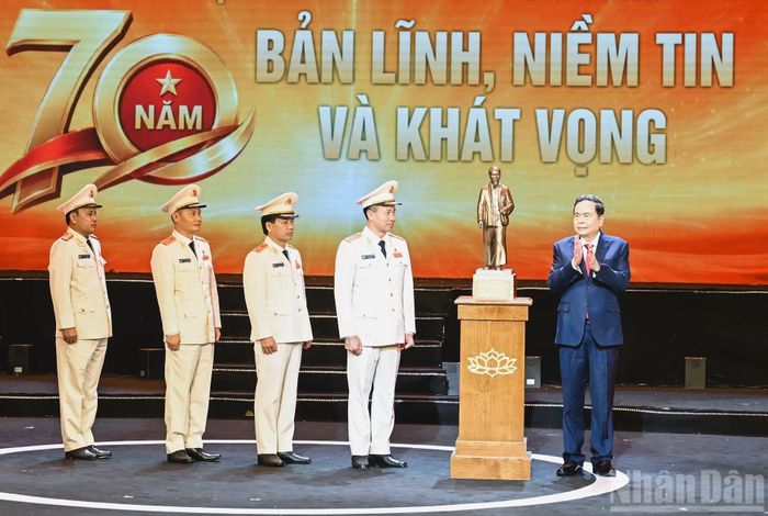 Chủ tịch Quốc hội Trần Thanh Mẫn trao bức tượng Chủ tịch Hồ Chí Minh tặng lực lượng Cảnh sát kinh tế. (Ảnh: DUY LINH)