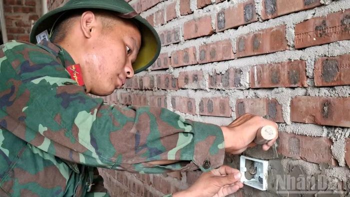 Cán bộ, chiến sĩ Trung đoàn 335 hỗ trợ lắp đặt thiết bị điện.