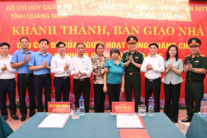 Thượng tá Nguyễn Văn Việt, Phó chính ủy Bộ CHQS tỉnh Quảng Ninh, cùng các đại biểu chụp ảnh cùng bà Đỗ Thị Định, con đẻ của người hoạt động kháng chiến bị nhiễm chất độc hóa học, tại khu phố 11, phường Cẩm Phả.  