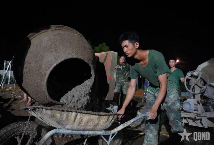  Chiến sĩ Trung đoàn 880, Bộ CHQS tỉnh Lai Châu làm việc vào ban đêm để kịp tiến độ bàn giao nhà cho bà con.
